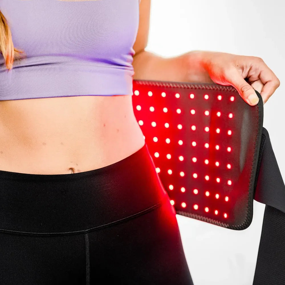 Woman using the re-nū 120 LED Red Light Therapy Belt on her abdomen to boost collagen and reduce wrinkles.