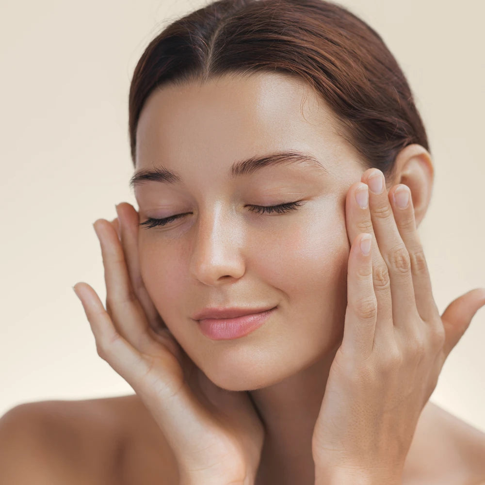 Woman with eyes closed and a happy expression, smiling while showing her freshly groomed and polished nails after using the electric nail trimmer with polisher.