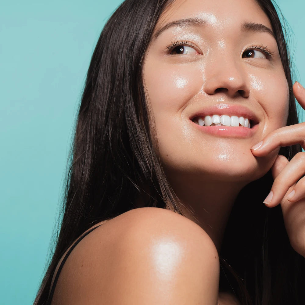 Smiling woman enjoying her skincare routine with the GlowUp Skin Care Fridge by her side, highlighting satisfaction and luxury in beauty care.