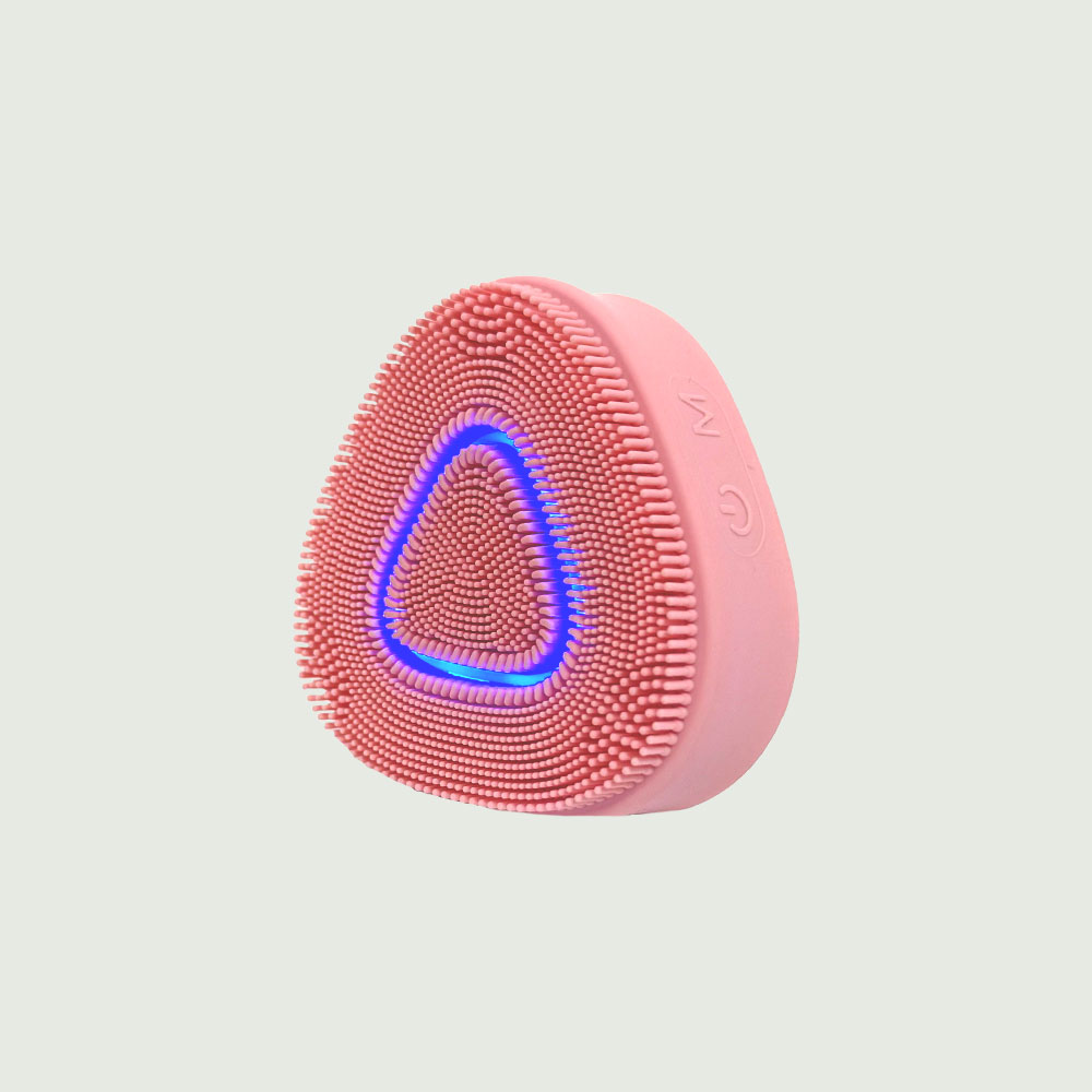 PurePulse Pro Sonic Cleansing Brush in pink featuring a blue LED light, soft silicone bristles and sleek ergonomic design for facial cleansing
