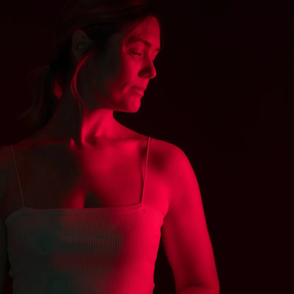 Close-up of woman using red light panel Pro for neck rejuvenation and tightening