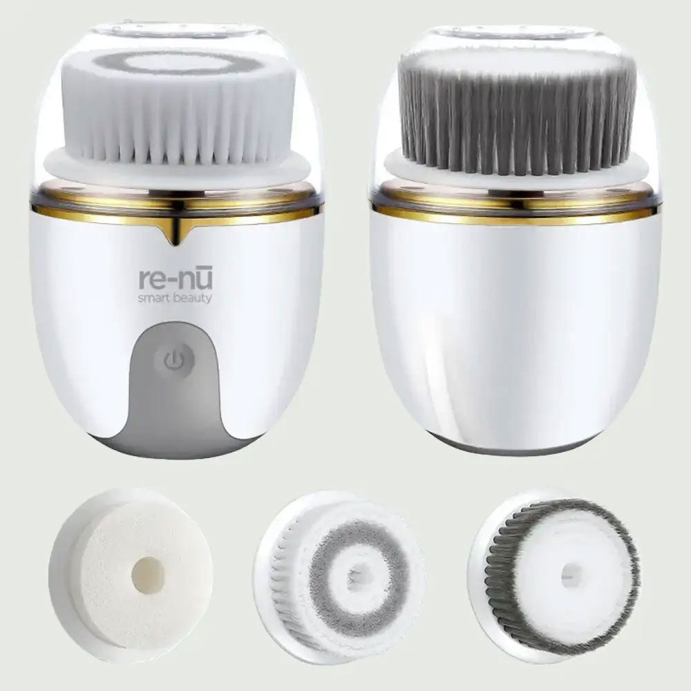 PureSpin Rotating Facial Cleansing Brush with soft gray bristles, white and gold waterproof body, and re-nū Smart Beauty logo – rechargeable skincare device for deep pore cleansing and exfoliation