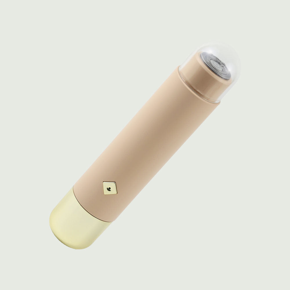 Tilted image of the Double-Headed Personal Grooming Trimmer, highlighting it's sleek design and hypoallergenic floating shaving head with cap.