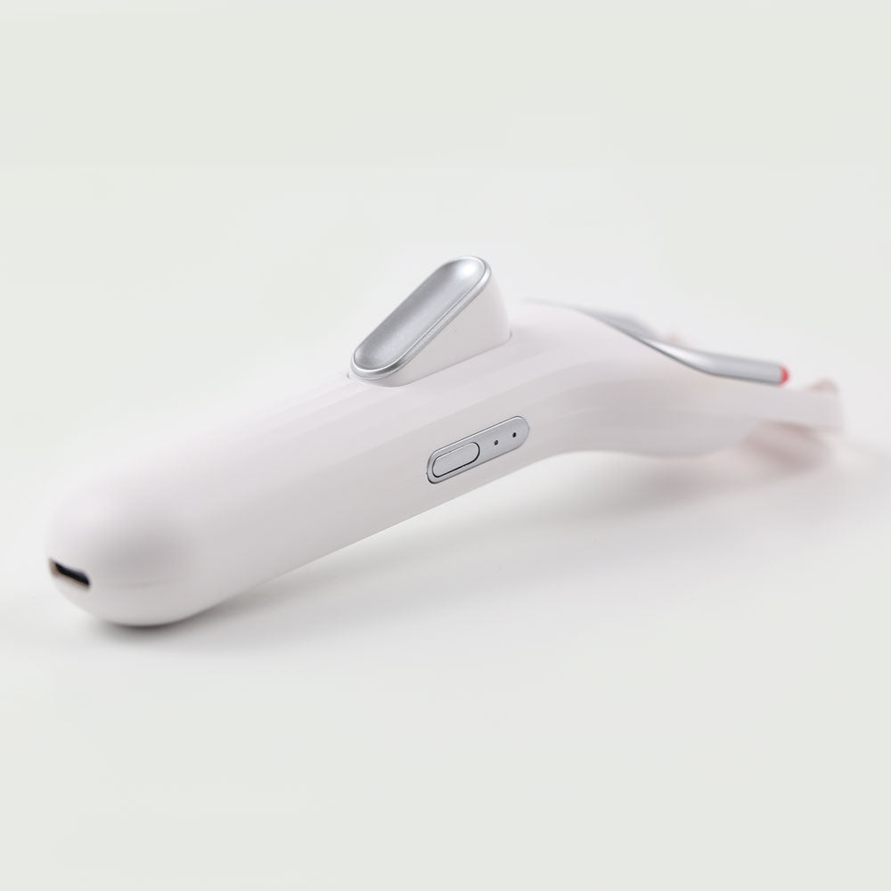 Angled view of heated eyelash curler with USB-C charging port, highlighting portable and eco-friendly design.
