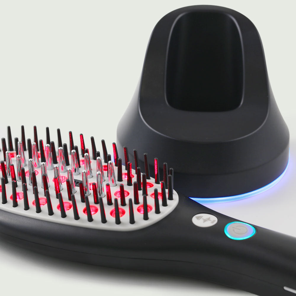 A side angle view of the Laser Hair Growth Brush and base, highlighting its cordless and rechargeable design.
