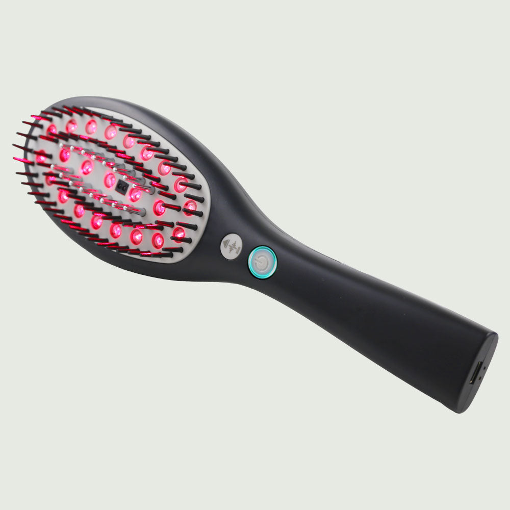Side view of the Laser Hair Growth Brush, showing its advanced red light hair brush bristles, illuminated push button controls, and conveniently located USB charging port.
