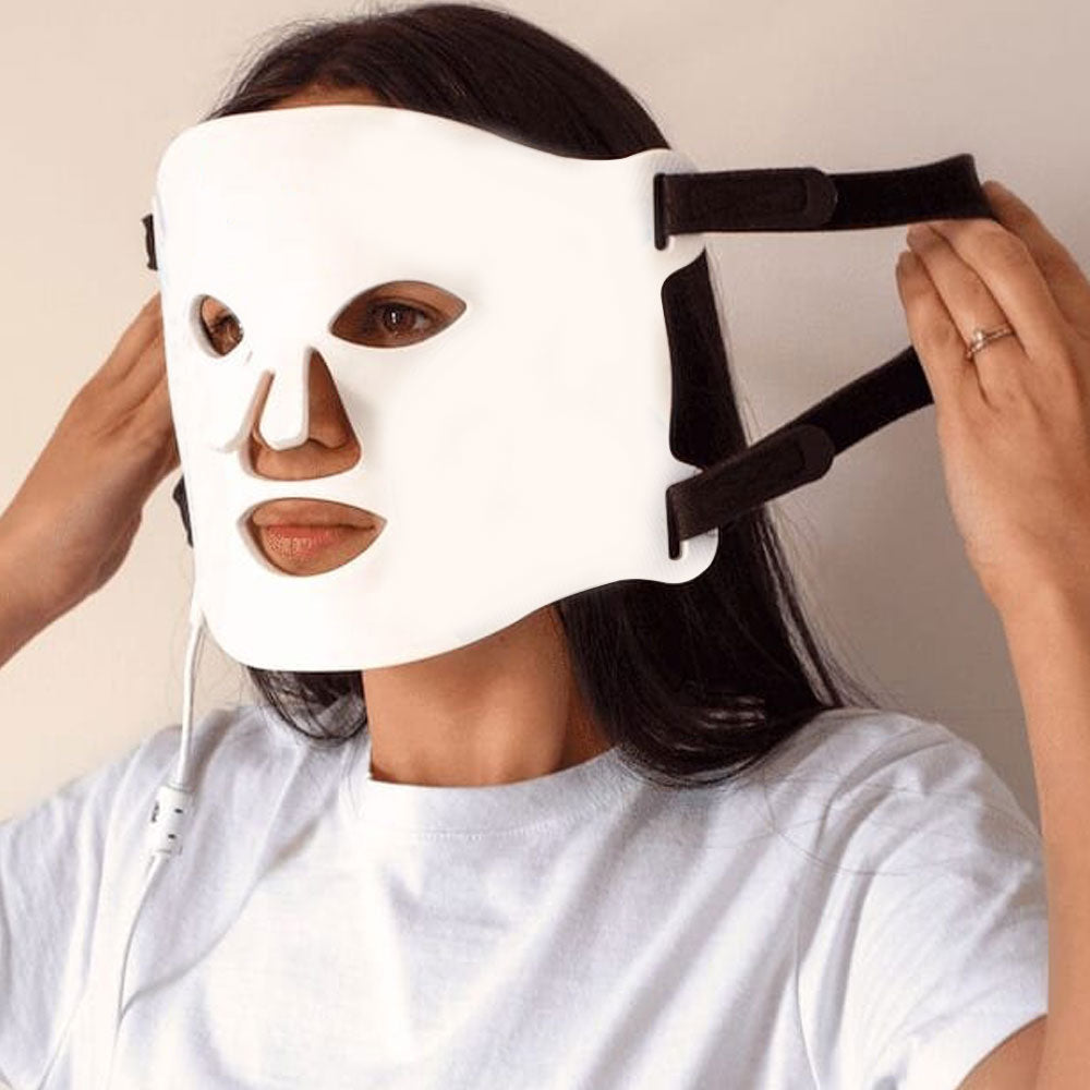 Woman at home wearing LED Beauty Mask, targeting wrinkles and collagen production