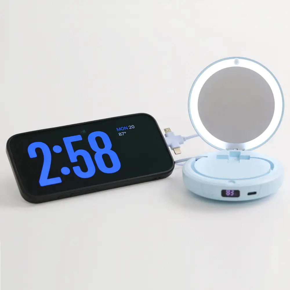 Blue re-nū LED Mirror + Power Bank charging a phone with mirror open and LED light on
