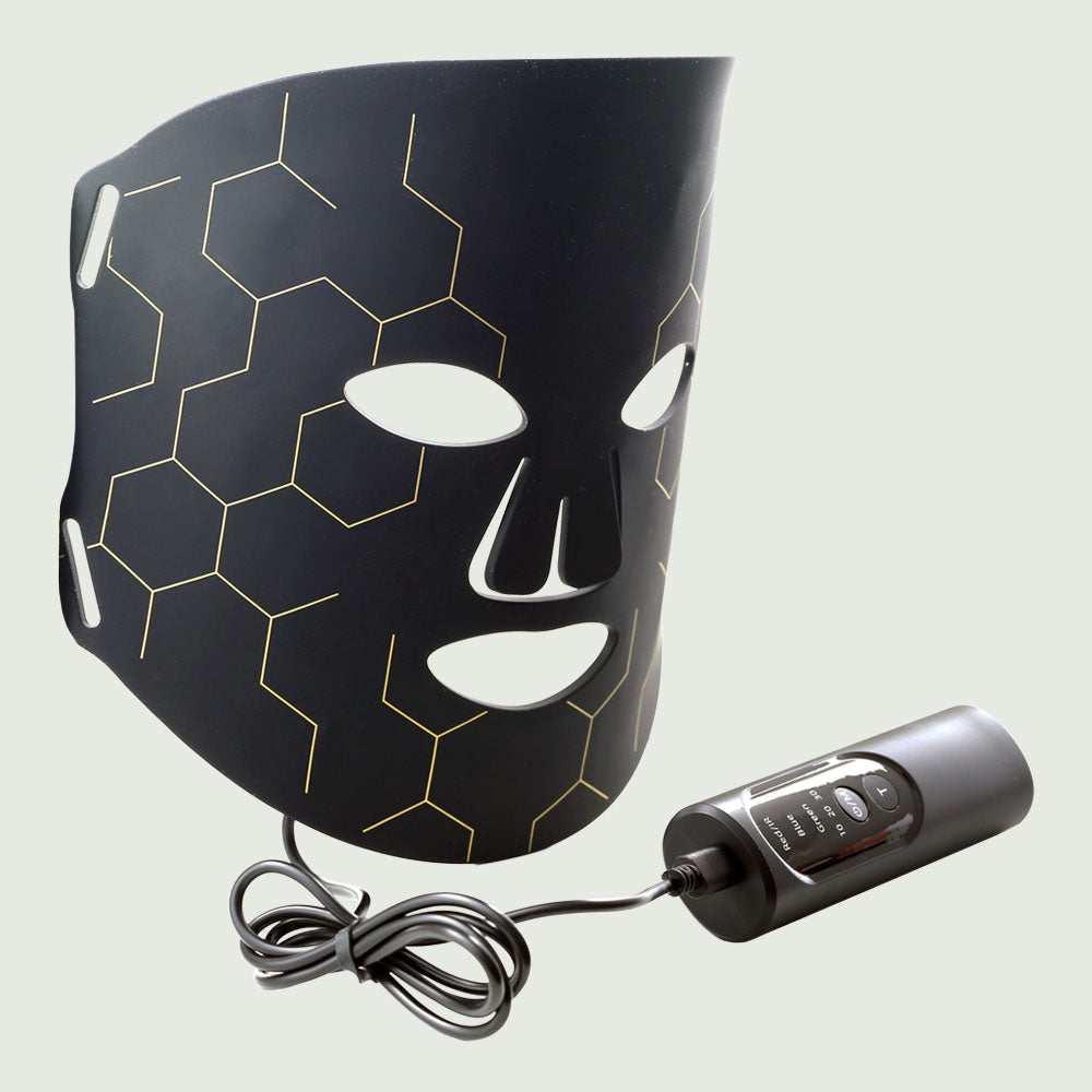 Multi-Color Light Therapy Mask – Advanced Skincare LED Therapy in slightly folded position beside connected remote controller with wire
