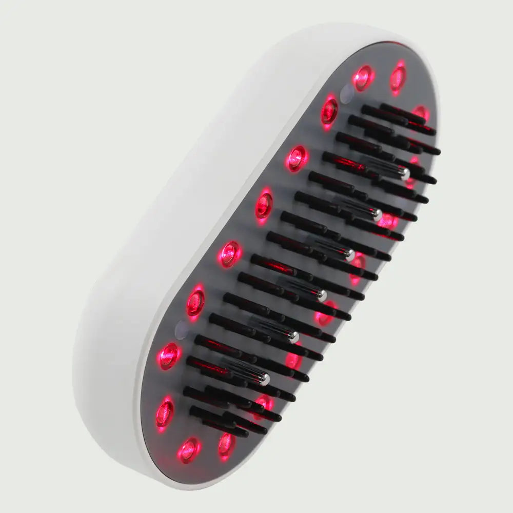 Closeup view of the Plasma Laser Therapy Hair Growth Comb by re-nū Smart Beauty, showing red laser diodes and microcurrent comb teeth.
