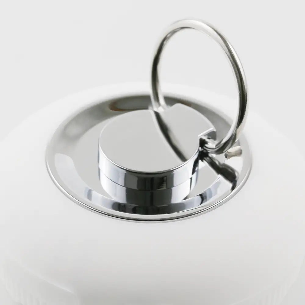 A close-up view of the PurePulse Sonic Cleansing Brush showing it's sleek silver ring handle, for easy portability.