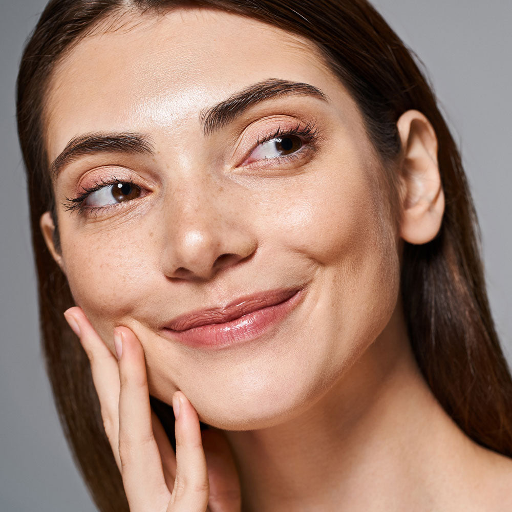 Woman smiling and showing her glowing, lifted skin after using the re-nū RF LED Microcurrent Face-Lifting Device, highlighting visible improvement in tone and smoothness.