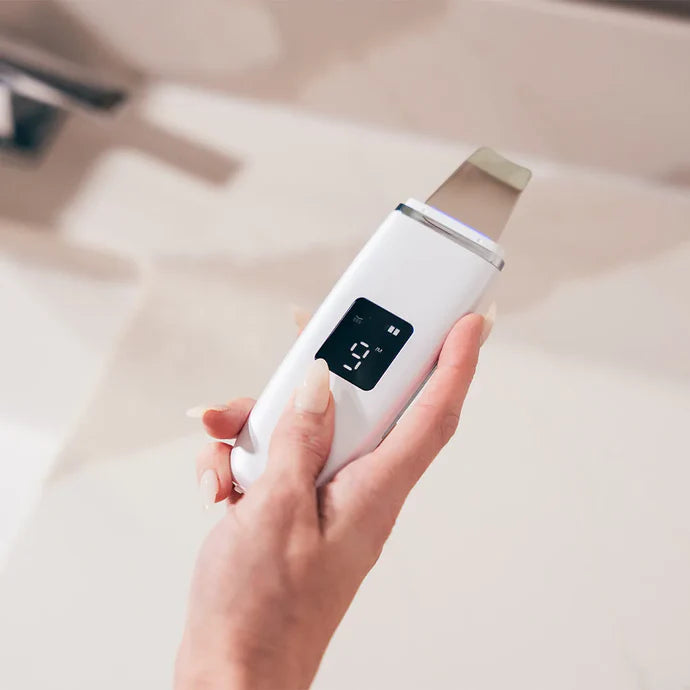 Hand holding Ultrasonic Facial Scrubber for deep pore cleansing and exfoliation