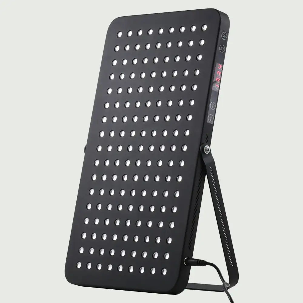 Angled view of the LED Red Light Therapy Panel Elite – UltraThin, supported by its stand and showcasing its slim, modern design and easy-to-read display.