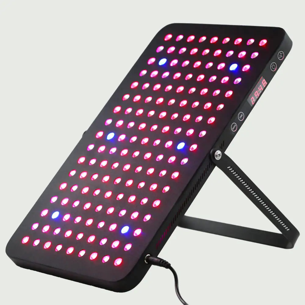 Angled view of the LED Red Light Therapy Panel Elite – UltraThin, fully lit with red, near-infrared, and blue LEDs in all modes, supported by its stand and showcasing its slim, modern design and easy-to-read side display.