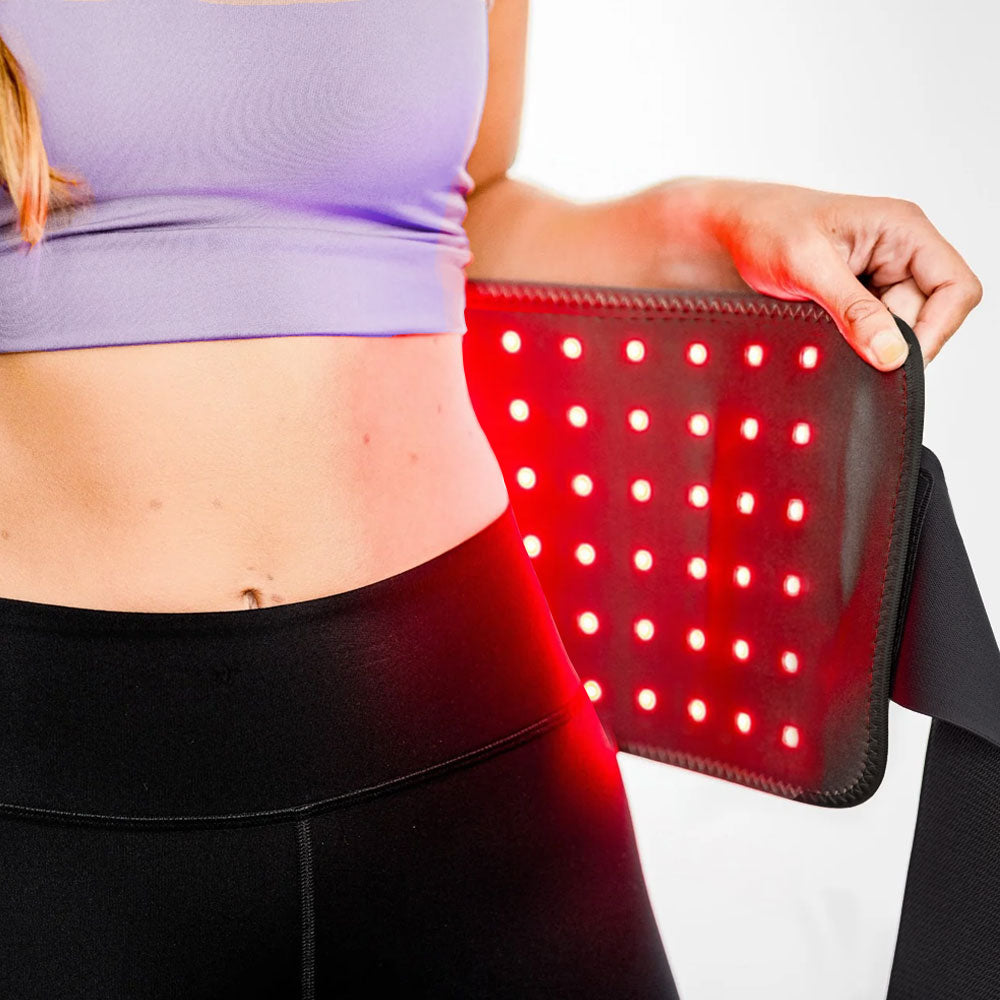Woman using the re-nū 120 LED Red Light Therapy Belt on her abdomen to boost collagen and reduce wrinkles.