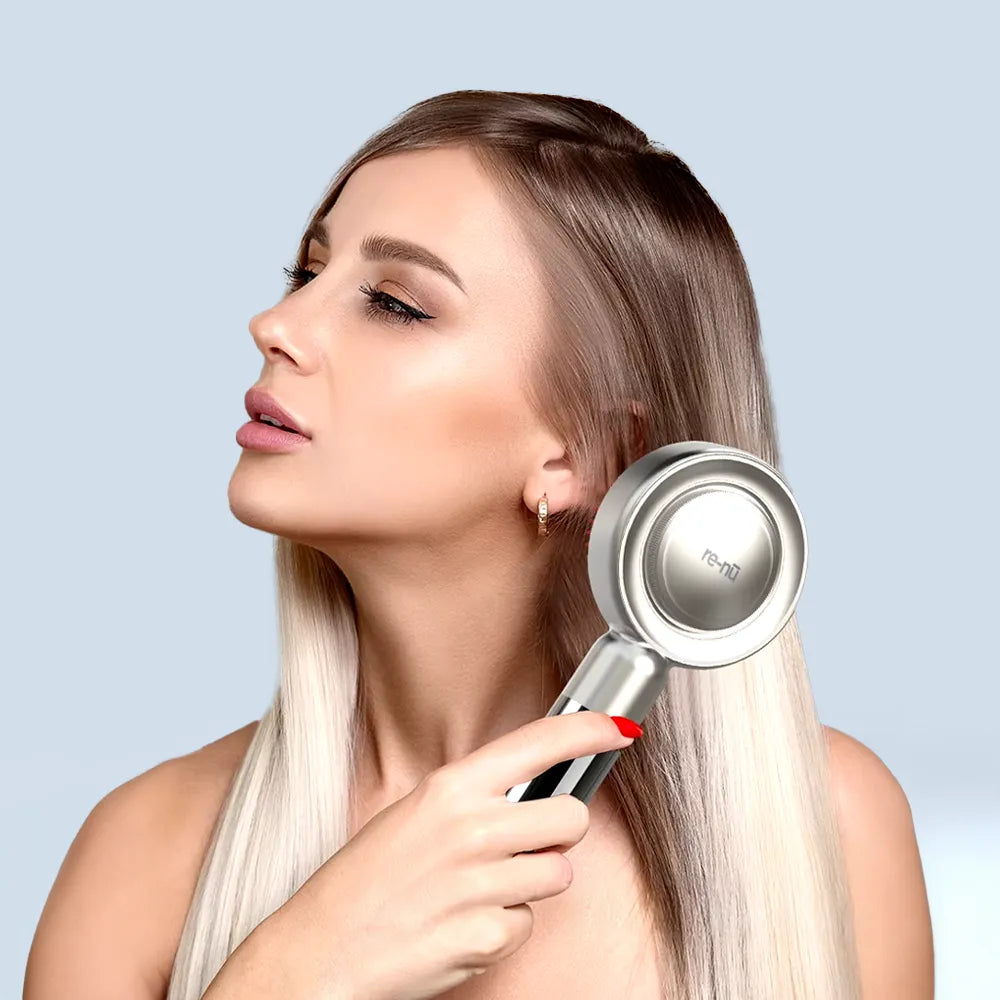 Woman using LED Therapy Massage Comb in her hair for red light and EMS stimulation to support hair regrowth.