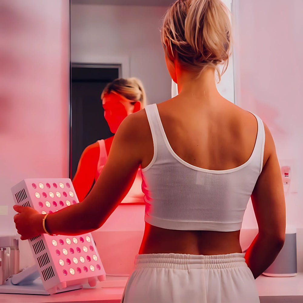 A woman is receiving treatment with a red light therapy machine, promoting skin health and wellness.