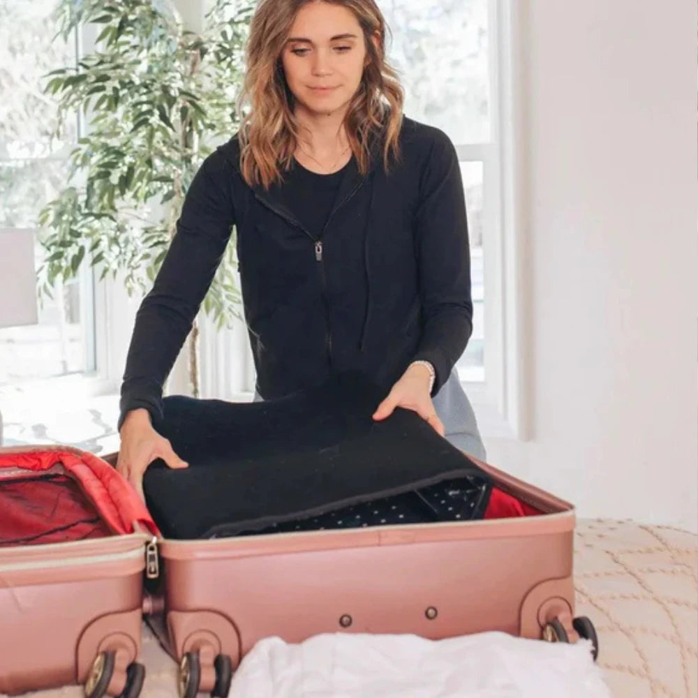 Woman folding and packing LED red light therapy mat into carry bag for travel or storage