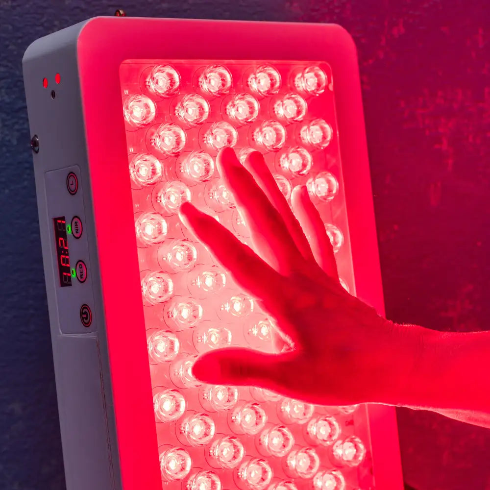A hand reaching toward a large LED red light therapy panel, illustrating high-intensity treatment for skin health and pain relief.