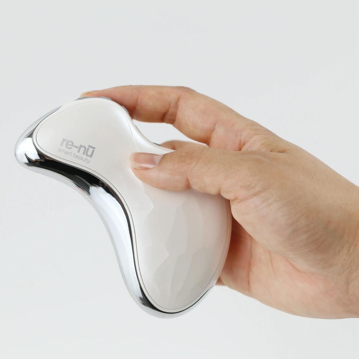 Close-up of a hand holding the Heated Sonic Gua Sha Facial Massager, showing its compact size and ergonomic, easy-to-grip design.