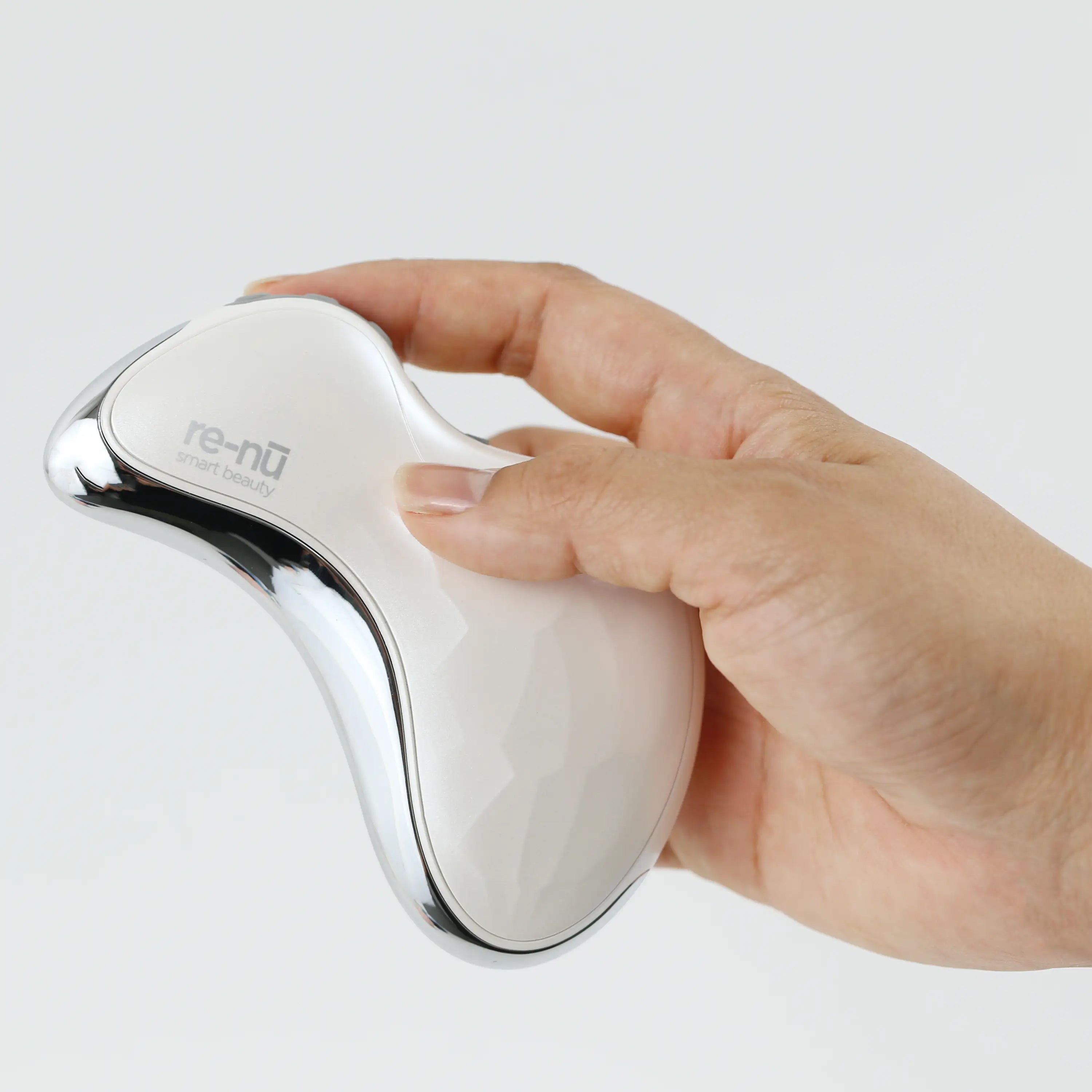 Close-up of a hand holding the Heated Sonic Gua Sha Facial Massager, showing its compact size and ergonomic, easy-to-grip design.