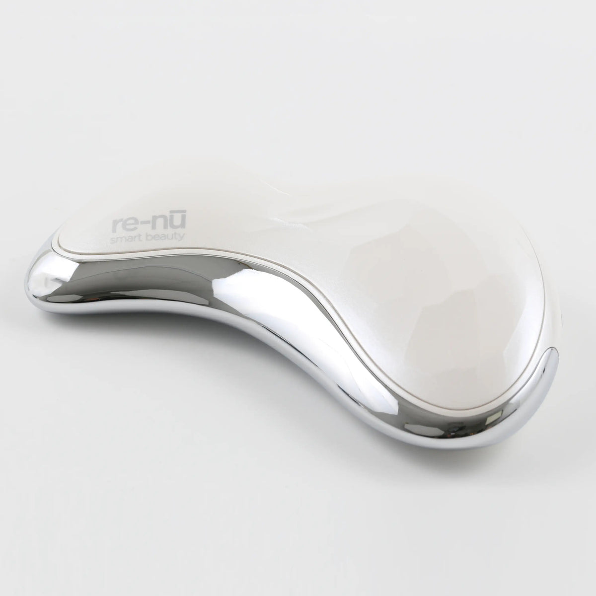 Angled flat 3/4 view of the Heated Sonic Gua Sha Facial Massager with a soft blurred background, showcasing the reflective chrome finish, clean design, and smooth, sculpted edges.