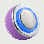PurePulse Pro Plus Sonic Cleansing Brush shown in 3/4 angle with blue LED glow, chrome EMS treatment head, textured silicone cleansing surface, and sleek ergonomic design
