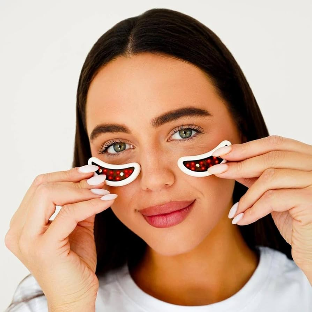 A woman displays two eye patches featuring red and white eyes, promoting LED light therapy for skin rejuvenation.