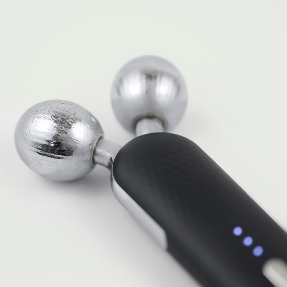 Close-up of re-nū Cold Therapy EMS Dual Roller showcasing both cryo roller and EMS V-roller heads.

