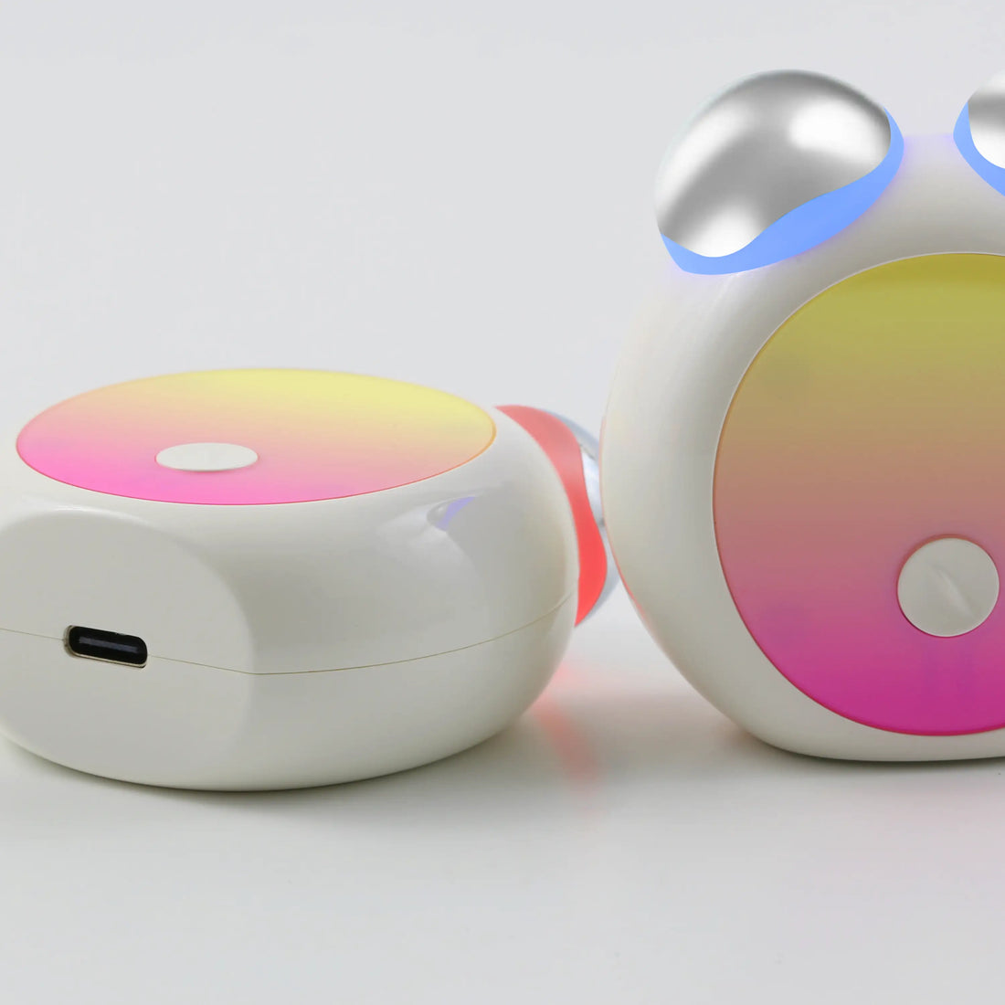 Bottom and front views of the compact LED Facial Toning Massager featuring an ergonomic design, visible red and blue LED lights, and USB-C charging port.