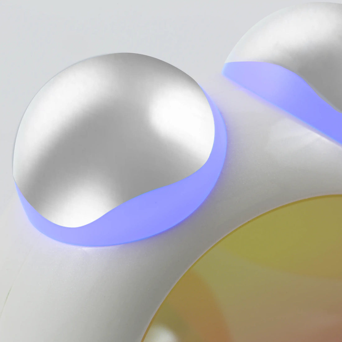 Closeup of the compact LED Facial Toning Massager featuring an ergonomic design, visible  blue LED lights, and high-frequency microcurrent EMS massage rollers.