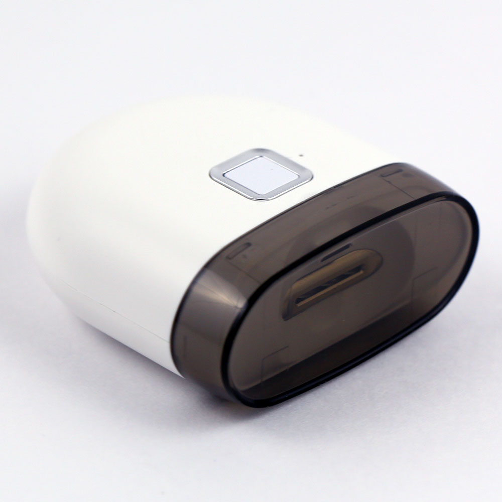 Electric Nail Trimmer laid flat showing the ergonomic design, recessed power button and secure translucent lid. 