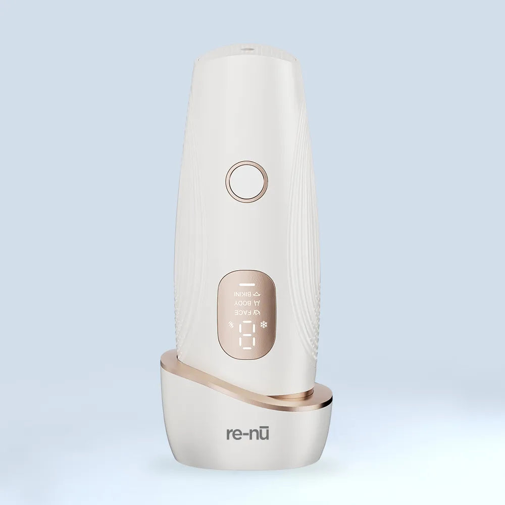 A sleek white and gold rechargeable LED skincare device with light therapy settings, displayed upright on a matching charging base.