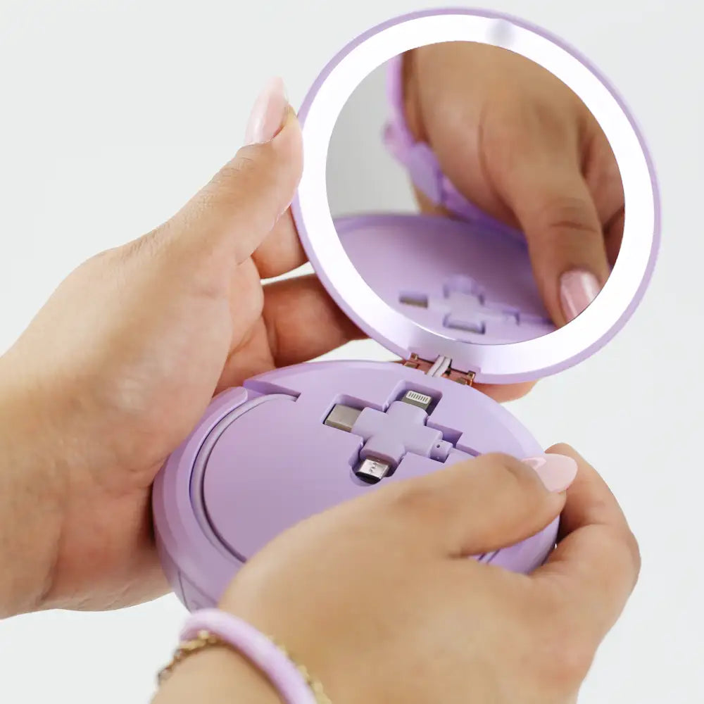 Closeup of a woman's hands holding he re-nū LED Mirror + Power Bank with Digital Display, highlighting the built-in universal USB connecting cable.