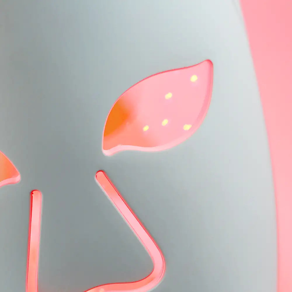 Close-up of the mask eye softly glowing red, highlighting smooth silicone surface