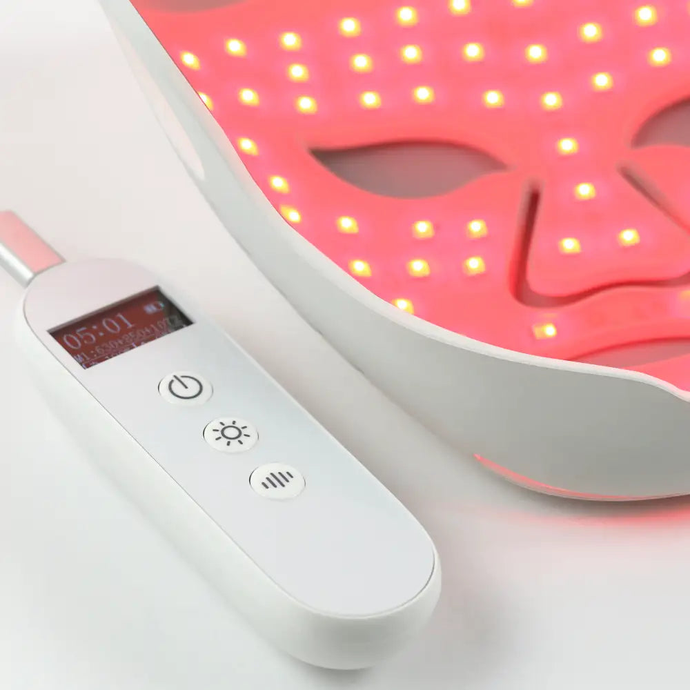 Close-up of the controller against the re-nū LED Mask with LEDs glowing bright red