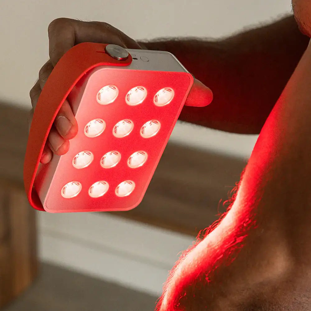Man using the Mini LED Red Light Panel on is arm, helping to reduce pain and discomfort at home