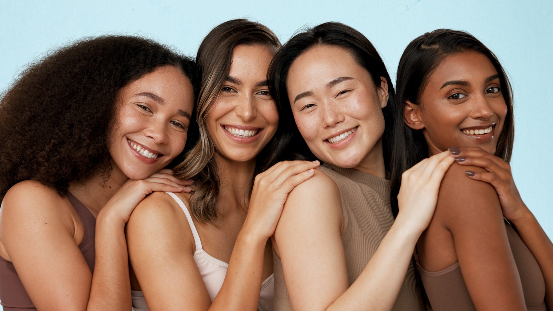  Five women smiling and posing together, showcasing their radiant skin after a Mask LED Light Therapy session.