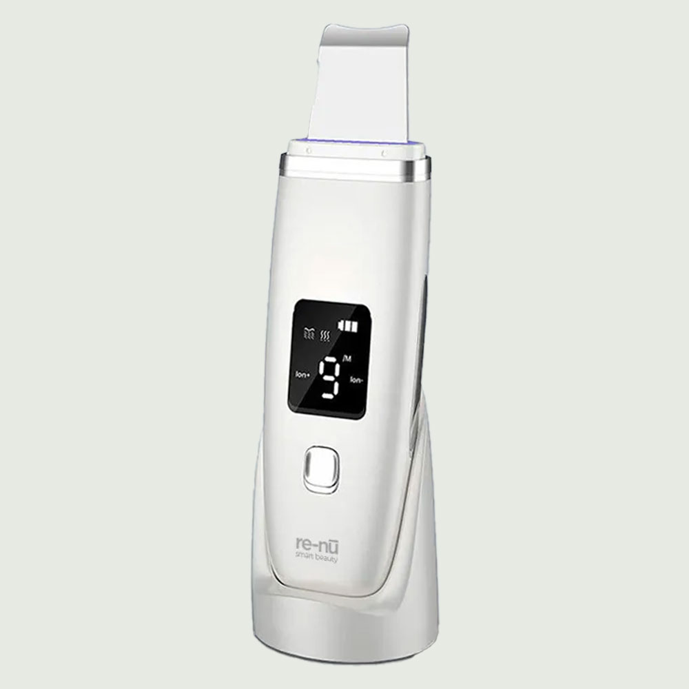A silver re-nū Smart Beauty ultrasonic skin scrubber with digital display and stainless steel spatula head, designed for deep facial cleansing, blackhead removal, and exfoliation.

