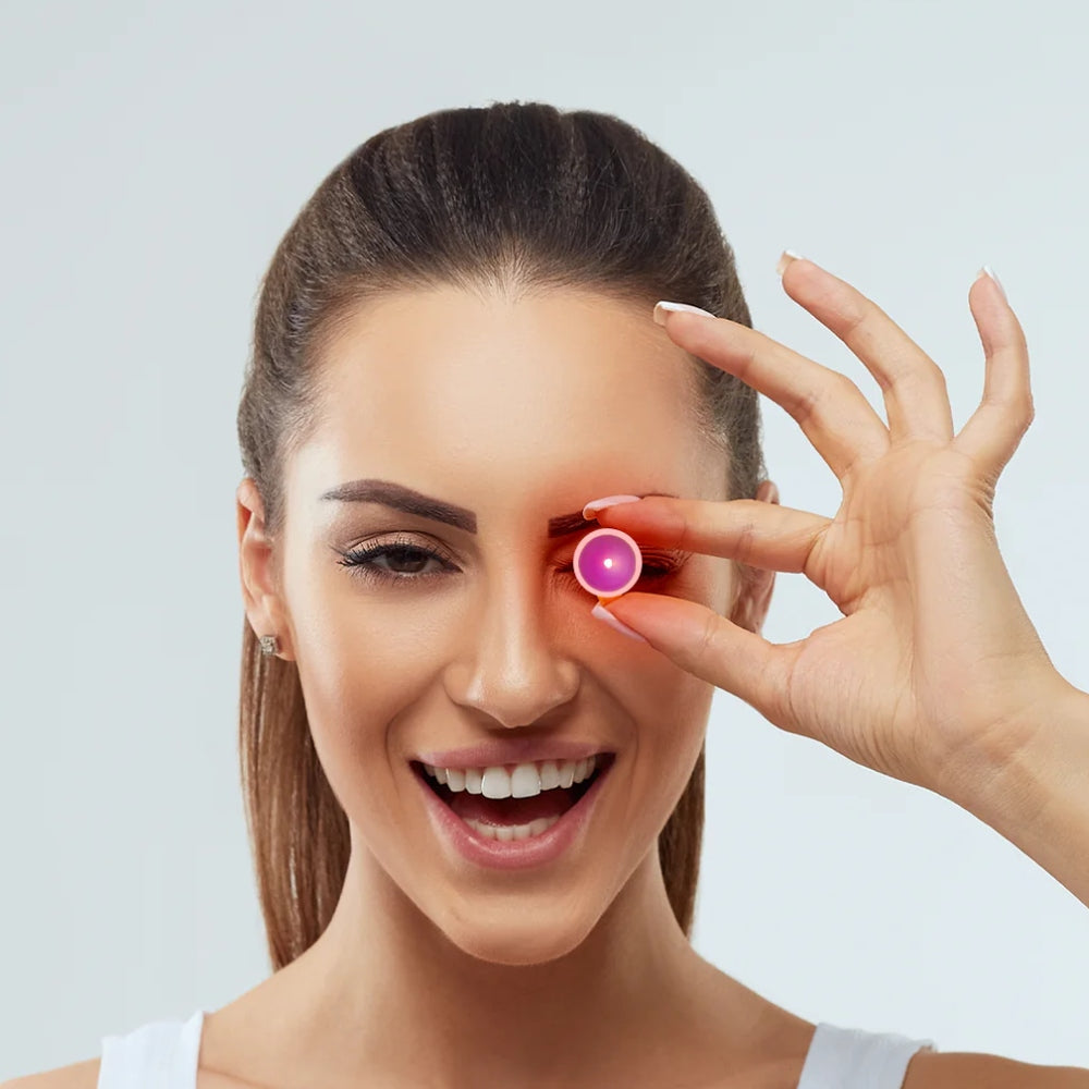 A woman displays a pink eye patch designed for LED light therapy, emphasizing its therapeutic benefits for eye care.