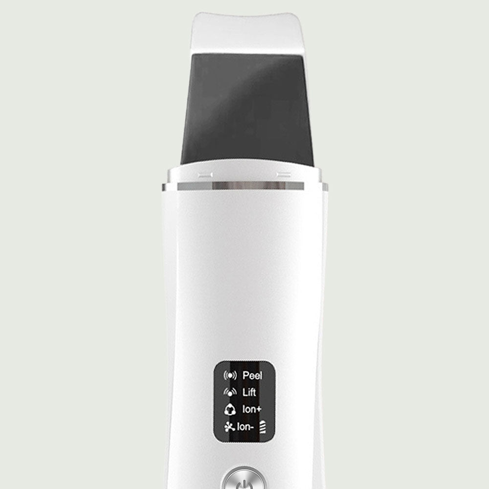 Close-up of stainless steel spatula tip of Ultrasonic Skin Scrubber showing high-frequency vibration with water droplets for visual impact.