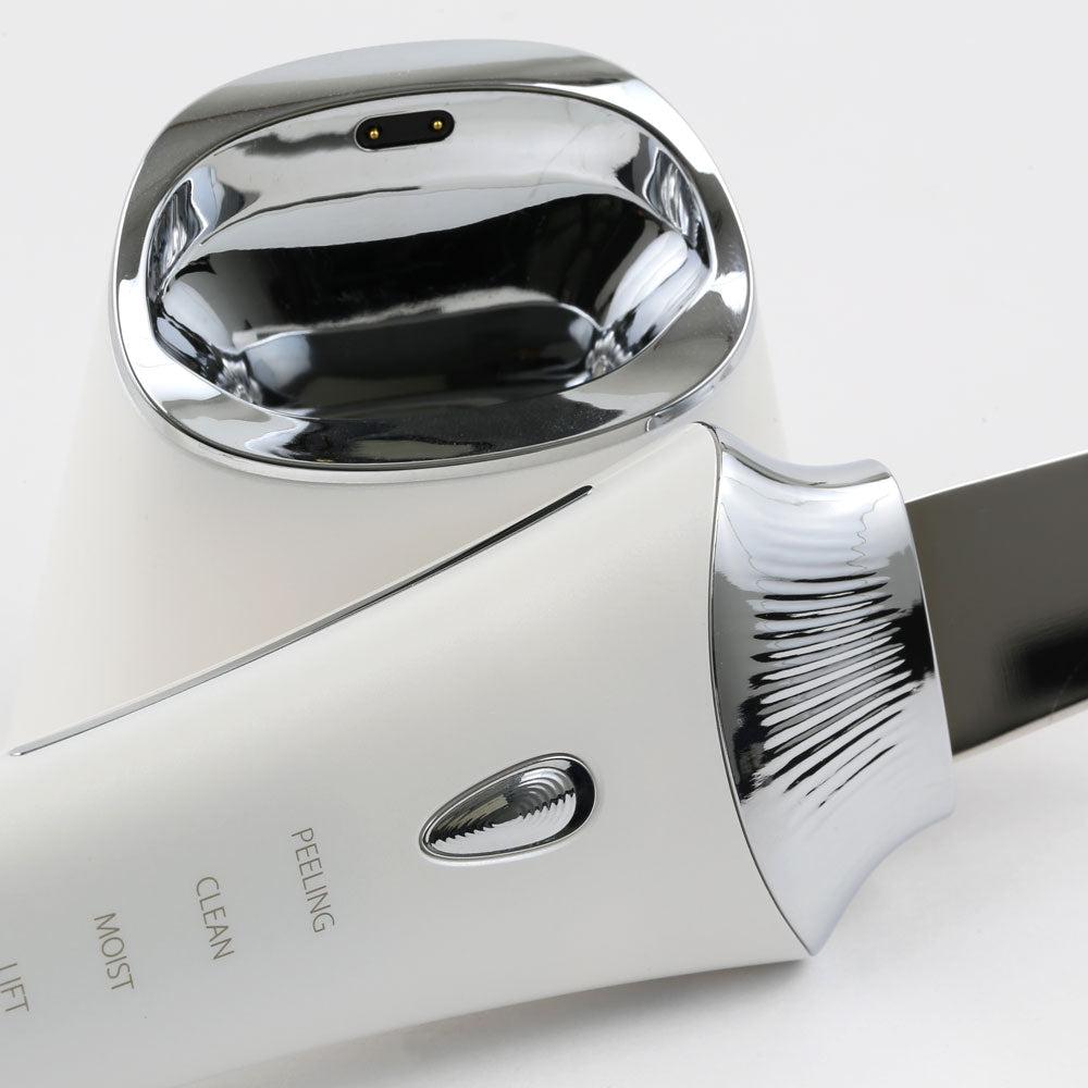 Closeup side view of the Ultrasonic Skin Scrubber with UV Base, highlighting its wireless UV charging base and easy to use power/mode button.