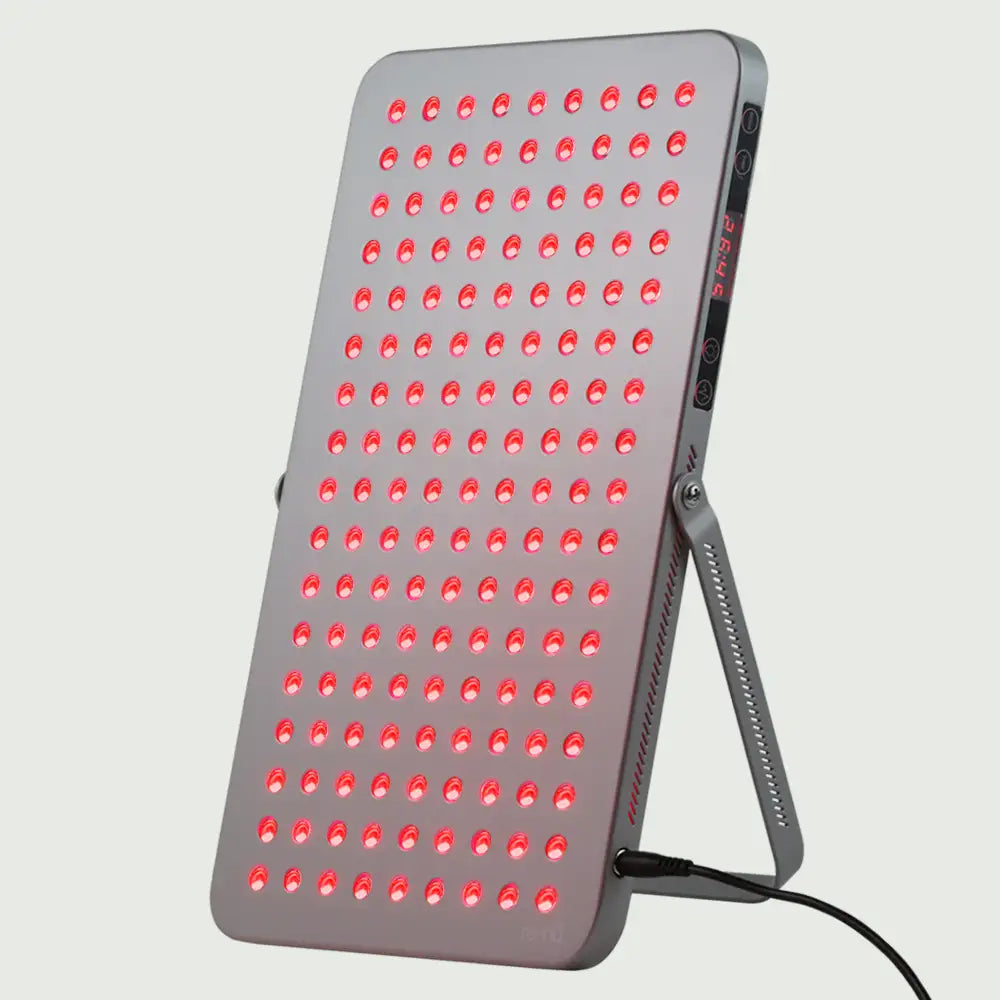 Angled view of the Gray LED Red Light Therapy Panel Elite – UltraThin, fully lit with red, near-infrared, and blue LEDs in all modes, supported by its stand and showcasing its slim, modern design and easy-to-read side display.