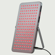 Angled view of the Gray LED Red Light Therapy Panel Elite – UltraThin, fully lit with red, near-infrared, and blue LEDs in all modes, supported by its stand and showcasing its slim, modern design and easy-to-read side display.