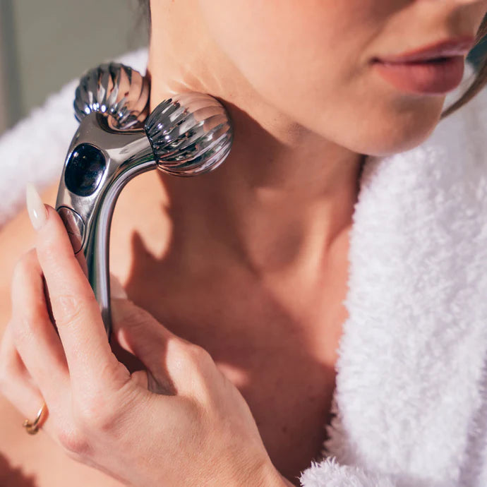Woman using the Vibrating EMS Massage Roller on her neck area, demonstrating its lifting and skin-tightening benefits with the dual V-shaped rollers in contact with the skin